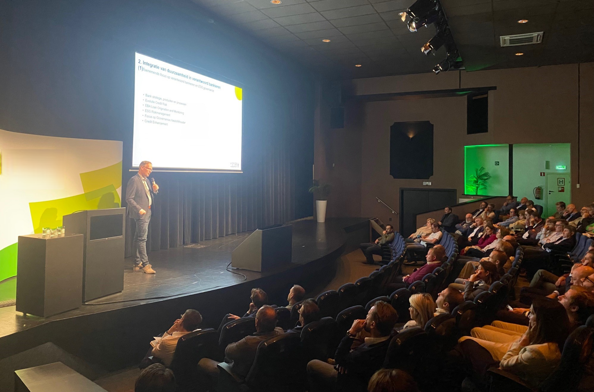Martin de Bruin als keynote speaker op het podium voor een volle zaal